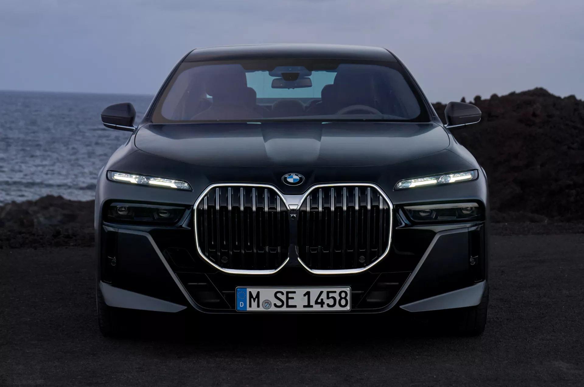 BMW 7 Series with illuminated kidney grille at dusk